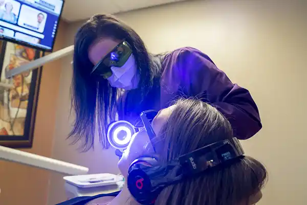 One of our dental hygienists taking care of a patient in the dentist chair