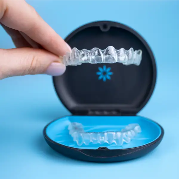 Close up of someone holding an Invisalign clear aligner