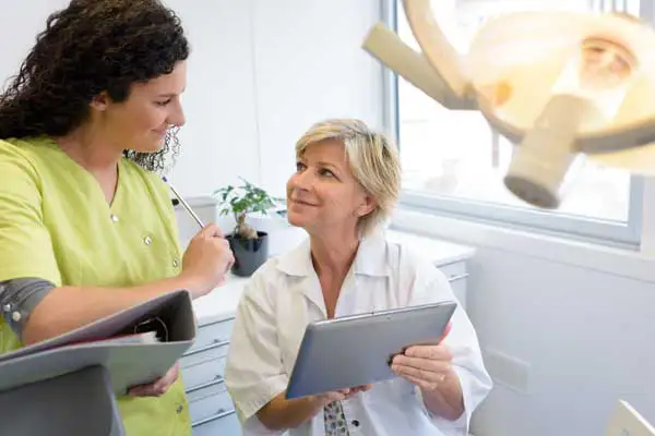 Dental hygienist consulting with a dentist in the office 